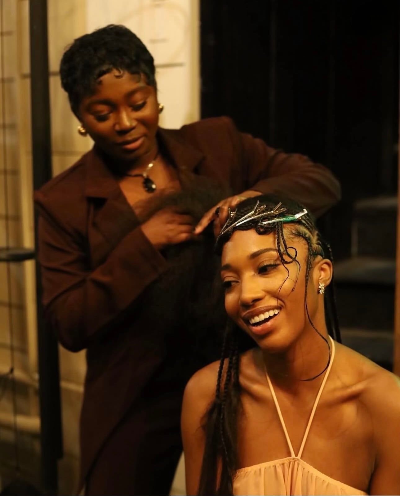 Live braiding at an event — stylist finishing a client’s knotless braids